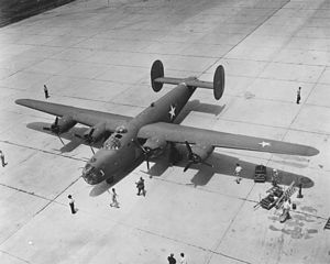 B-24 Liberator on concrete runway, people looking