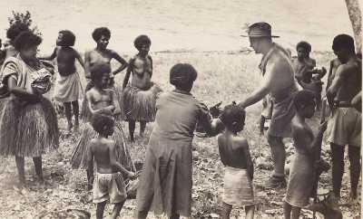 Australian soldier giving supplies to Papuans