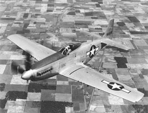 bubble canopy P-51 Mustang flying over farmland